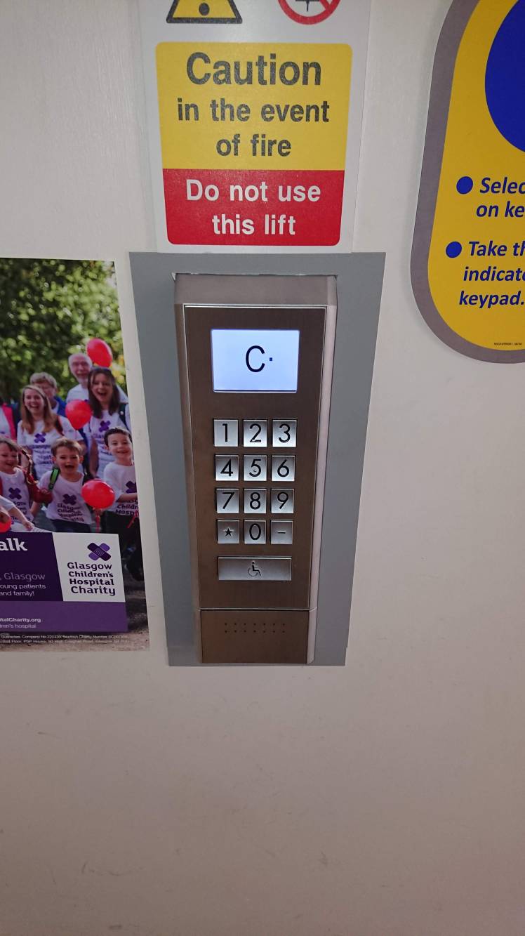 A lift control panel with a numeric keypad and the letter C in the display