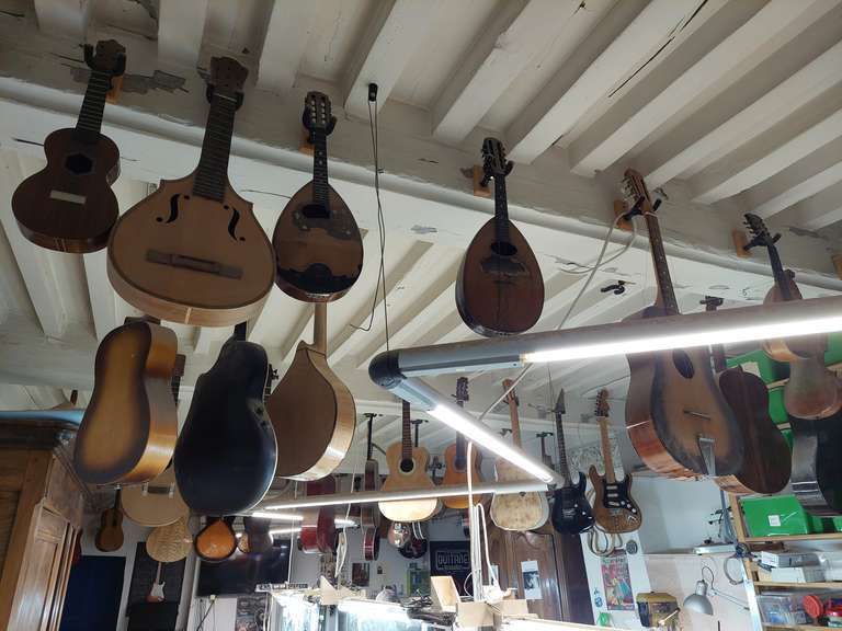 Des instruments de musique pendus au plafond dans un atelier de lutherie